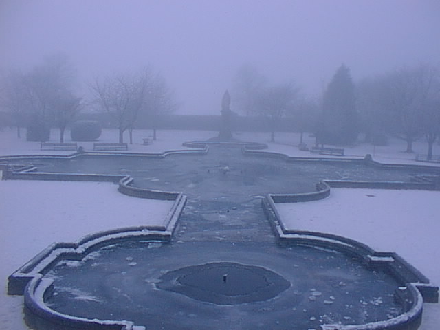 A view of the frozen water behind the war memorial with the Queen Victoria monument in the distance